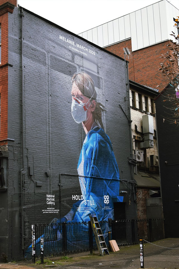 Symbolbild: Street-Art-Porträt einer Krankenschwester mit Maske an einer Hauswand in Manchester. Der gemeinnützige Sektor in Großbritannien wird durch die Krise doppelt belastet. Foto: Matthew Waring, unsplash.com